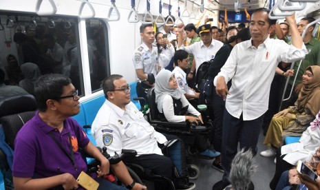 Presiden Joko Widodo berbincang dengan penumpang difabel ketika mencoba MRT dengan rute stasiun Bundaran HI-Lebak Bulus-Istora di Jakarta, Kamis (21/3/2019).