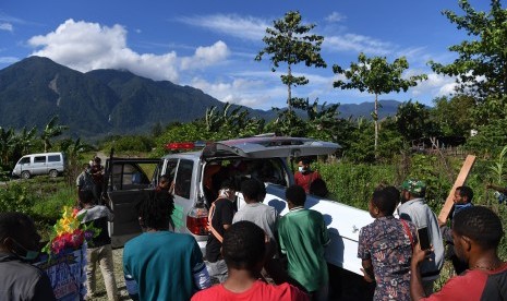 Keluarga duka mengangkat peti yang berisi jenazah korban banjir bandang Sentani ke dalam mobil jenazah untuk dimakamkan di Sentani, Jayapura, Papua, Sabtu (23/32019). 