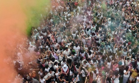 Sejumlah warga dan wisatawan saling melemparkan bubuk warna-warni saat Festival Holi di Denpasar, Bali, Sabtu (23/3/2019).