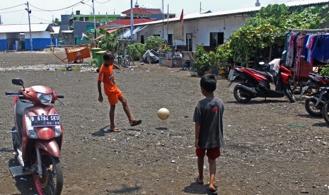 Anak-anak bermain di lapangan dekat shelter atau hunian sementara di Kampung Akuarium, Jakarta, Selasa (26/3/2019). 