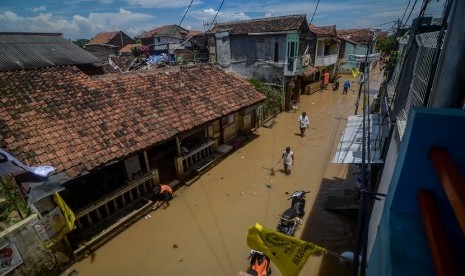 Warga melintasi banjir yang menggenangi Desa Bojongasih, Dayeuhkolot, Kabupaten Bandung, Jawa Barat, Rabu (27/3/2019). 