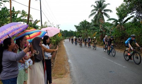 Penonton memberi semangat kepada Pebalap saat mengikuti Tour de Bintan 2019 di Kabupaten Bintan Provinsi Kepri, Sabtu (30/3/2019). Pemerintah Kabupaten Bintan, Kepulauan Riau, menargetkan sebanyak 3.000 orang wisatawan mancanegara (wisman) mengunjungi daerah tersebut saat Tour de Bintan.