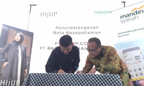 Direktur Technology & Operation Mandiri Syariah Achmad Syafii (kanan) bersama Chief of Business Operation & Sales Officer HIJUP Akli Djumadie (kiri) menandatangani nota kesepahaman tentang layanan jasa dan produk perbankan berdasarkan prinsip syariah di Living Stone, Bali, Senin (1/4). 