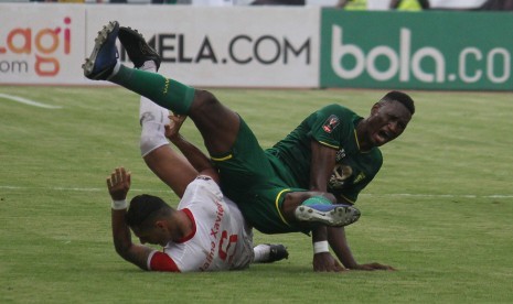 Pesepak bola Persebaya Surabaya Amido Balde (kanan) dijegal pesepak bola Madura United Jaimerson Da Silva Xavier (kiri) saat pertandingan semifinal Piala Presiden 2019 leg pertama melawan Madura United di Stadion Gelora Bung Tomo, Surabaya, Jawa Timur, Rabu (3/4/2019).