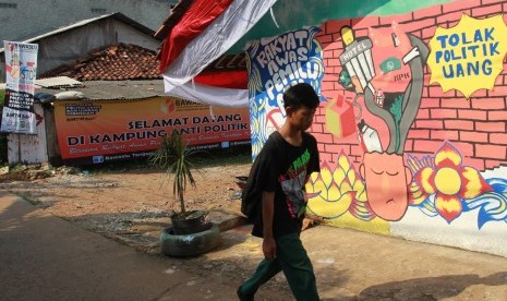 Warga melintasi kampung tematik yang bertemakan Kampung Anti Politik Uang di Pondok Aren, Tangerang Selatan, Banten, Kamis (4/4/2019).