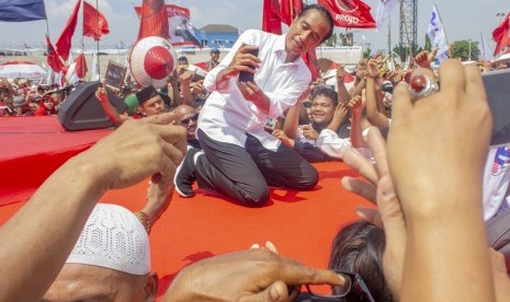 Calon Presiden nomor urut 01 Joko Widodo (tengah) berswafoto dengan pendukung saat kampanye akbar di Stadion Singaperbangsa, Karawang, Jawa Barat, Selasa (9/4/2019). 