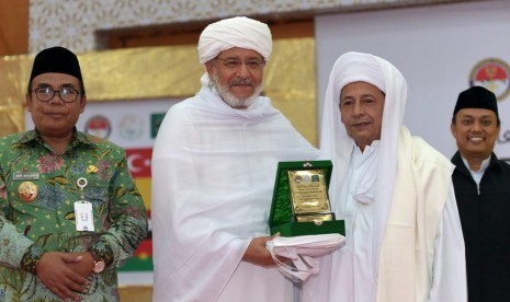 Syekh Muhammad As-Syuhumi Al-Idrisi asal Libya (kedua kiri) menerima cenderamata berupa plakat dari Habib Luthfi bin Ali bin Yahya (kanan) pada agenda penutupan Konferensi Ulama Sufi Internasional di Pekalongan, Jawa Tengah, Rabu (10/4). 