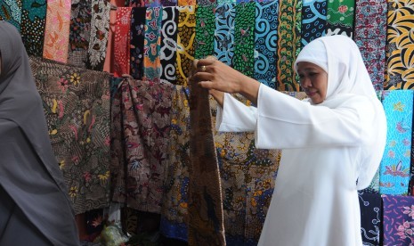 Gubernur Jawa Timur Khofifah Indar Parawansa mengamati batik yang akan dibeli di Pasar 17 Agustus, Pamekasan, Jawa Timur, Sabtu (13/4/2019). 