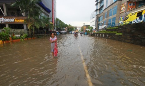 Warga melintasi banjir di kawasan jalan Lambung Mangkurat, Banjarmasin, Kalimantan Selatan, Sabtu (20/4/2019). 