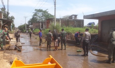 Jajaran BPBD Kabupaten Bandung, TNI dan Polri serta masyarakat membersihkan lumpur sisa banjir di wilayah Baleendah, Bojongsoang dan Dayeuhkolot, Senin (22/4).