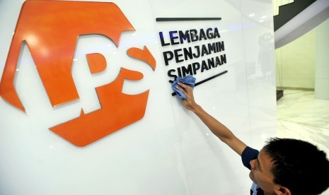 Karyawan membersihkan logo baru Lembaga Penjamin Simpanan (LPS) di Jakarta, Selasa (23/4/2019).