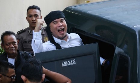 Terdakwa kasus dugaan pencemaran nama baik Ahmad Dhani Prasetyo (kanan) masuk ke mobil tahanan usai mengikuti sidang tuntutan di Pengadilan Negeri Surabaya, Jawa Timur, Selasa (23/4/2019). 