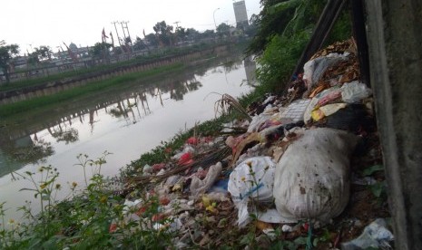 Warga membuang sampah sembarangan di Sepanjang aliran sungai Kalimalang di Jalan KH Noer Ali,  Tambun Selatan, Kabupaten Bekasi