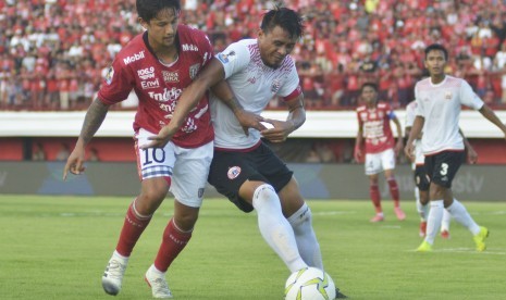 Pesepak bola Bali United Irfan Bachdim (kiri) berebut bola dengan pesepak bola Persija Jakarta Maman Abdurahman (kanan) saat pertandingan leg pertama perempat final Piala Indonesia di Stadion Kapten I Wayan Dipta, Gianyar, Bali, Jumat (26/4/2019). 