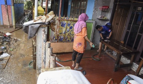 Warga membersihkan rumah dan harta bendanya pascabanjir merendam kawasan Kelurahan Rawajati di Jakarta, Senin (29/4/2019).