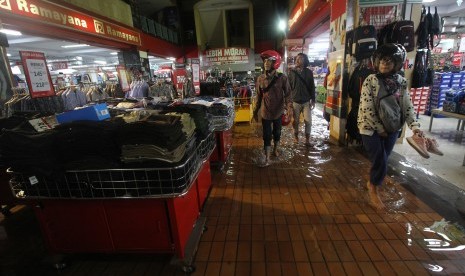 Pengunjung berjalan di samping pakaian yang dijual di Hi-Tech Mall yang terendam banjir di Surabaya, Jawa Timur, Senin (29/4/2019). 