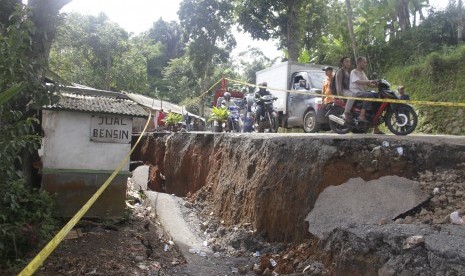 Sejumlah pengendara kendaraan bermotor melintasi jalan yang ambles di Jalan Sukabumi-Sagaranten, Kampung Gunungbatu, Desa Kertaangsana, Nyalindung, Sukabumi, Jawa Barat, Kamis (2/5/2019).