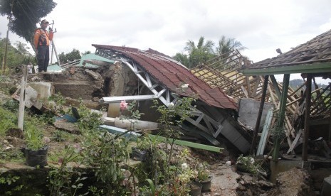 Petugas Badan Penanggulangan Bencana Daerah (BPBD) mengamati salah satu rumah rusak terdampak bencana gerakan tanah di Desa Kertaangsana, Kecamatan Nyalindung, Sukabumi, Jawa Barat, Kamis (2/5/2019).