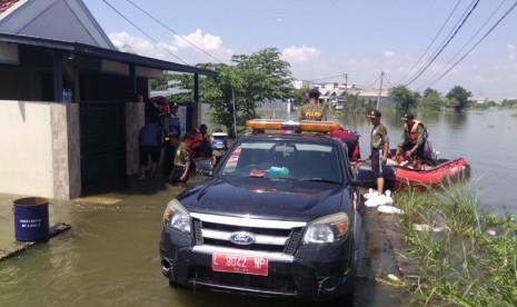 Petugas dari Pemkot Surabaya mengangkut handbag menggunakan perahu boat untuk menutup tanggul Anak Kali Lamong yang jebol di RW 03, Kelurahan Sumberejo, Kecamatan Pakal, Kota Surabaya, Jumat (3/5)