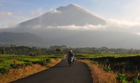 Pengendara melintasi Kayu Aro Barat dengan latar Gunung Kerinci, Jambi, Jumat (3/5/2019). 