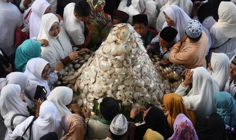 Warga bersiap-siap membagikan kue apem saat digelar 'Magengan Kubro' di Masjid Al Akbar Surabaya, Jawa Timur, Jumat (3/5/2019). 