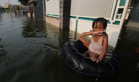 Seorang anak bermain air banjir di kawasan Kelurahan Sumberejo, Kecamatan Pakal, Surabaya, Jawa Timur, Jumat (3/5/2019).