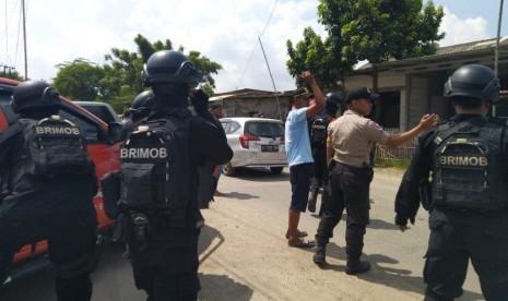 Seorang pengendara sedang melintas di depan lokasi penggerebekan terduga teroris di RT 11 RW 04, Desa Kedung Pengawas, Babelan, Kabupaten Bekasi, Sabtu (4/5). Penggerebekan oleh Tim Densus 88 pada pukul 04.00 WIB itu mengakibatkan 1 orang terduga teroris tewas ditempat.