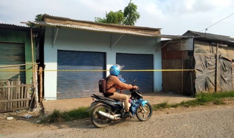 Seorang pengendara sedang melintas di depan lokasi penggerebekan terduga teroris di RT 11 RW 04, Desa Kedung Pengawas, Babelan, Kabupaten Bekasi, Sabtu (4/5). Penggerebekan oleh Tim Densus 88 pada pukul 04.00 WIB itu mengakibatkan 1 orang terduga teroris tewas ditempat.