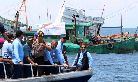 Menteri Kelautan dan Perikanan Susi Pudjiastuti (kanan) didampingi Wakil Kepala Staf Angkatan Laut Laksamana Madya TNI Wuspo Lukito (kedua kanan), Gubernur Kalimantan Barat Sutarmidji (ketiga kanan) dan Kapolda Kalbar Irjen Pol Didi Haryono (keempat kanan) berada di depan sejumlah kapal nelayan Vietnam saat penenggelaman di Pulau Datuk, Kabupaten Mempawah, Kalimantan Barat, Sabtu (4/5/2019). 