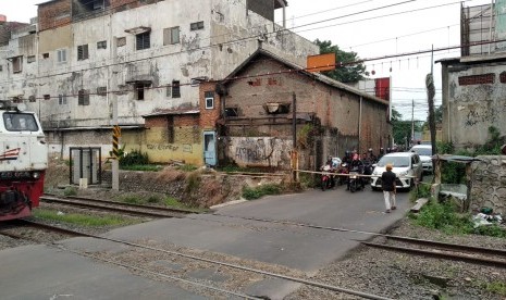 Penjaga perlintasan sebidang di Bulak Kapal, Kelurahan Aren Jaya, Bekasi Timur, Kota Bekasi, sedang menunggu kereta api melintas. Perlintasan sebidang tersebut merupakan satu dari dua perlintasan yang sampai saat ini tidak memiliki palang pintu di Kota Bekasi. 