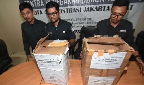 Petugas Bawaslu Jakarta Pusat menunjukkan kardus berisi ribuan form C1 Pemilu yang diamankan polisi dari sebuah mobil yang melaju di kawasan Menteng, Jakarta, di Gedung Bawaslu Jakarta Pusat, Senin (6/5/2019).