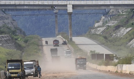 Sejumlah truk melintasi proyek pembangunan Jalan Tol Cileunyi-Sumedang-Dawuan (Cisumdawu) di Kabupaten Sumedang, Jawa Barat, Rabu (8/5/2019). 