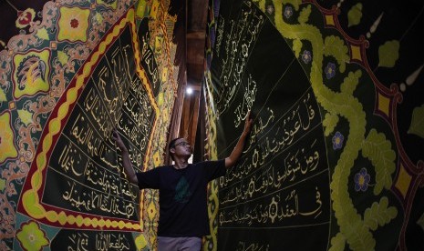 Perajin membuat batik motif ayat Al Quran di atas lembar kain di Mahkota Batik Laweyan, Solo, Jawa Tengah, Kamis (9/5/2019).