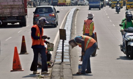 Pekerja PT Adhi Karya melakukan pengecatan median jalan di KM 19+700 di ruas Jalan Diponegoro Ungaran, Kabupaten Semarang, Jumat (10/5). Pekerjaan pemeliharaan jalan KBK ruas Banyumanik- Bawen ini juga diperuntukkan bagi penyiapan jalur utama non tol untuk mudik Lebaran tahun ini.