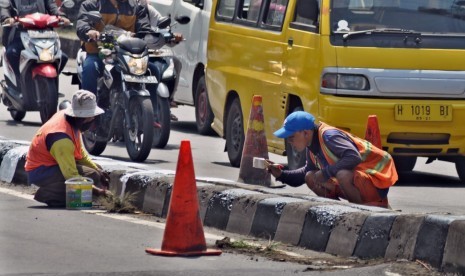 Pekerja PT Adhi Karya melakukan pengecatan median jalan di KM 19+700 di ruas Jalan Diponegoro Ungaran, Kabupaten Semarang, Jumat (10/5). Pekerjaan pemeliharaan jalan KBK ruas Banyumanik- Bawen ini juga diperuntukkan bagi penyiapan jalur utama non tol untuk mudik Lebaran tahun ini.