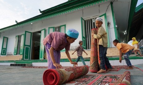 Sejumlah anak menyiapkan tempat berbuka puasa di Situs Cagar Budaya Masjid Al Amin atau biasa dikenal Masjid Tua Wani di Desa Wani, Kabupaten Donggala, Sulawesi Tengah, Jumat (10/5/2019). 