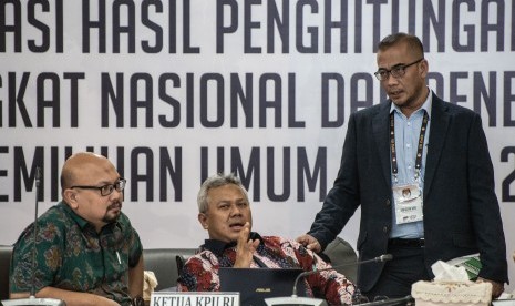 Ketua KPU Arief Budiman (tengah), para Komisioner KPU Hasyim Asy'ari (kanan) dan Ilham Saputra (kiri) berbincang di sela Rapat Pleno Rekapitulasi Hasil Penghitungan dan Perolehan Suara Tingkat Nasional Dalam Negeri dan Penetapan Hasil Pemilu 2019 di kantor KPU, Jakarta, Rabu (15/5/2019).