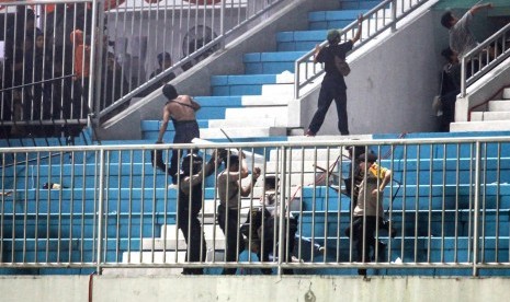 Polisi menghalau pendukung yang ricuh saat pertandingan Liga 1 antara PSS Sleman melawan Arema FC di Stadion Maguwoharjo, Sleman, DI Yogyakarta, Rabu (15/5/2019). 