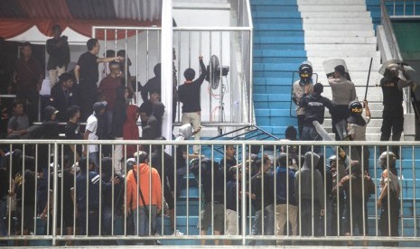 Polisi menghalau pendukung yang ricuh saat pertandingan Liga 1 antara PSS Sleman melawan Arema FC di Stadion Maguwoharjo, Sleman, DI Yogyakarta, Rabu (15/5/2019). 