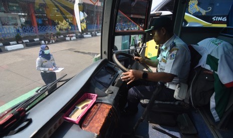 Petugas melakukan pengecekan kelayakan bus. 