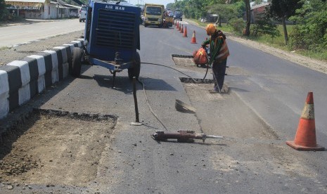 Pekerja menyelesaikan perbaikan jalur pantura Patrol, Indramayu, Jawa Barat yang saat ini banyak berlubang dan membahayakan pengemudi.