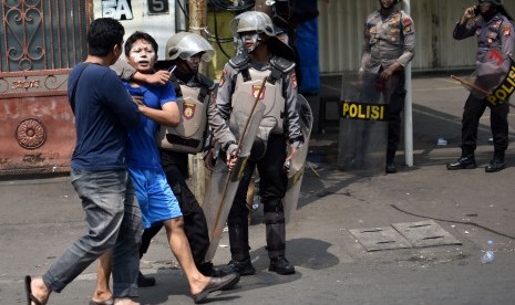 Sejumlah polisi mengamankan salah seorang warga yang diduga ikut aksi kerusuhan di Jalan KS. Tubun, Petamburan, Jakarta Pusat, Rabu (22/5/2019). 