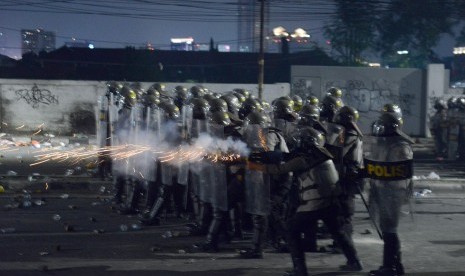 Personel kepolisian menembakkan gas air mata pada massa aksi 22 Mei di Jalan Brigjen Katamso, Slipi, Jakarta, Rabu (22/5/2019). 