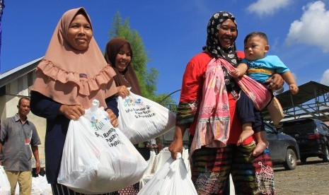 Sejumlah warga kurang mampu membawa paket sembako 