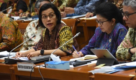 Menteri Keuangan Sri Mulyani Indrawati (kiri) dan Menteri Kesehatan Nila F. Moeloek (tengah) menyampaikan paparannya saat mengikuti rapat kerja dan rapat dengar pendapat dengan Komisi IX DPR di Kompleks Parlemen Senayan, Jakarta, Senin (27/5/2019).