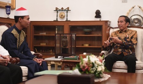 Presiden Joko Widodo (kanan) berbincang dengan pemenang Musabaqah Tilawatil Quran (MTQ) Internasional Ke-7 di Turki, Syamsuri Firdaus (kiri) dalam pertemuan di Istana Merdeka, Jakarta, Selasa (28/5/2019).