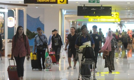 Calon penumpang pesawat udara membawa barang bawaan di Terminal Keberangkatan Domestik Bandara Internasional I Gusti Ngurah Rai, Bali, Jumat (31/5/2019). 