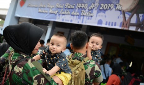 Seorang prajurit wanita TNI bersama anaknya menunggu daftar panggil ketika akan mudik di Lanud Halim Perdanakusuma, Jakarta Timur, Sabtu (1/6/2019).