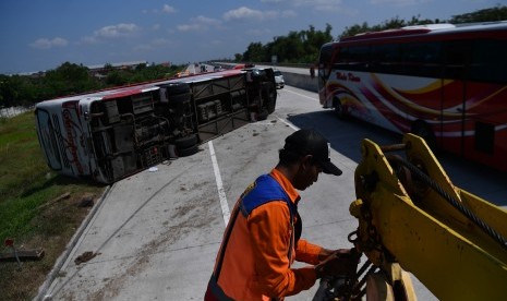 Petugas derek menyiapkan derek untuk menarik bus Sindoro Satriamas yang terguling di Jalan Tol Ngawi-Solo KM 525, Sragen, Jawa Tengah, Sabtu (1/6/2019).