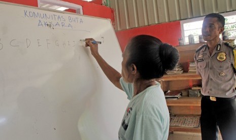 Seorang siswa buta aksara belajar menulis abjad, disaksikan Bhabinkamtibmas Brigpol Kresna Ola (kanan), di Rumah Merah Putih di desa Kenebibi, Kecamatan Kakuluk Mesak, Kabupaten Belu, NTT (ilustrasi) 